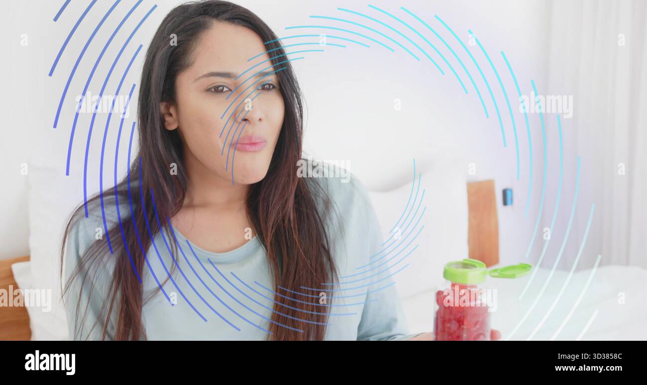 Tenant femme indienne portant le dessus bleu présentant pot de confiture rouge sur le lit, recouvrement numérique bleu Banque D'Images