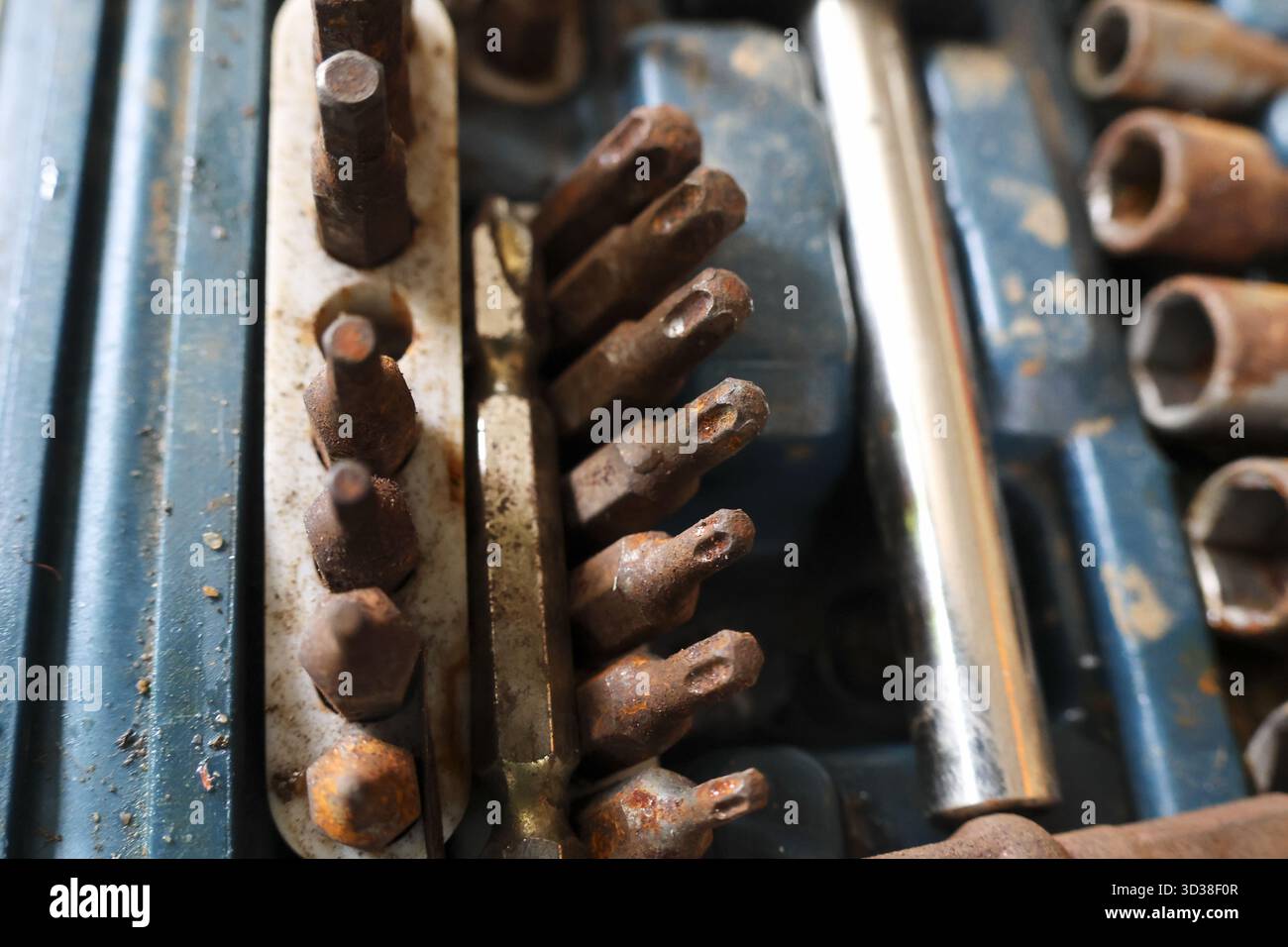 Gros plan d'une vieille boîte à outils en métal rouillé remplie d'équipement d'atelier vintage. collection d'embouts et de douilles de tournevis en acier montrant des années d'usure Banque D'Images