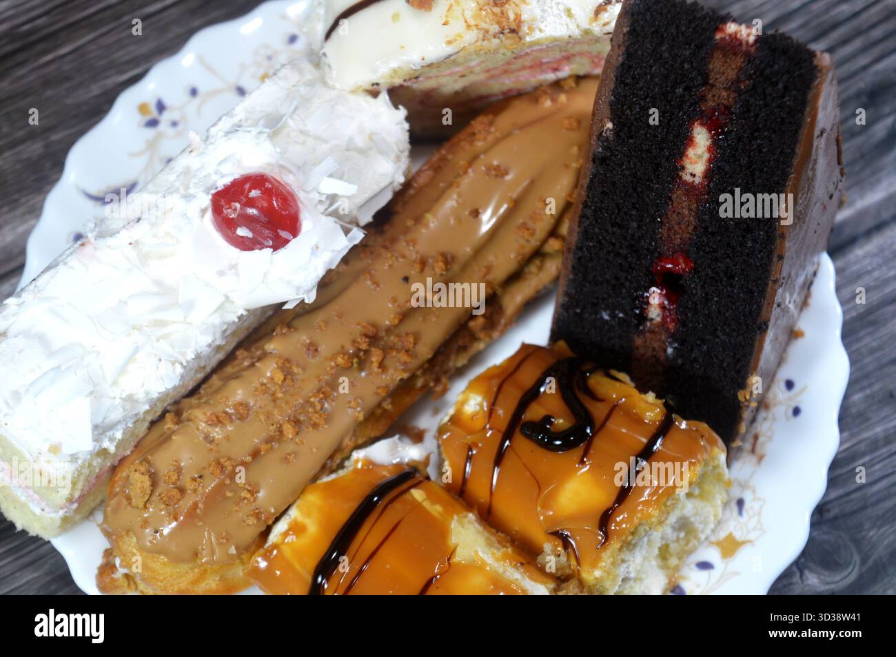 Gâteaux assortis, gâteau au chocolat, gâteau blanc de la forêt, biscuit en couches Eclair, pain de Suisse recouvert d'une couche de chocolat blanc et gâteau éponge fourré avec Banque D'Images