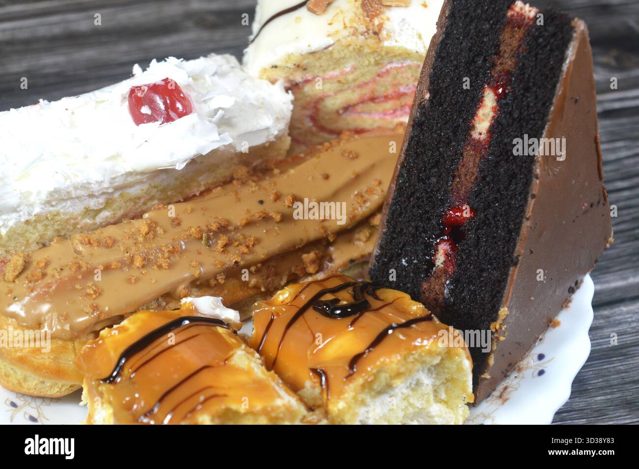 Gâteaux assortis, gâteau au chocolat, gâteau blanc de la forêt, biscuit en couches Eclair, pain de Suisse recouvert d'une couche de chocolat blanc et gâteau éponge fourré avec Banque D'Images