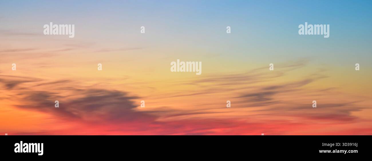 Magnifique panorama crépusculaire avec des nuages de coucher de soleil superposés et des transitions de couleurs fluides. Vue tranquille sur la lumière du jour qui s'estompe. Banque D'Images