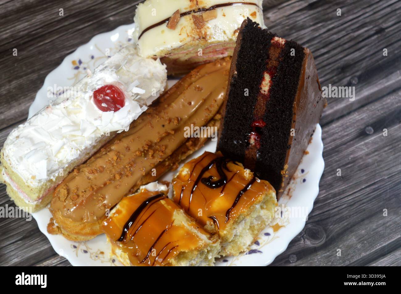 Gâteaux assortis, gâteau au chocolat, gâteau blanc de la forêt, biscuit en couches Eclair, pain de Suisse recouvert d'une couche de chocolat blanc et gâteau éponge fourré avec Banque D'Images