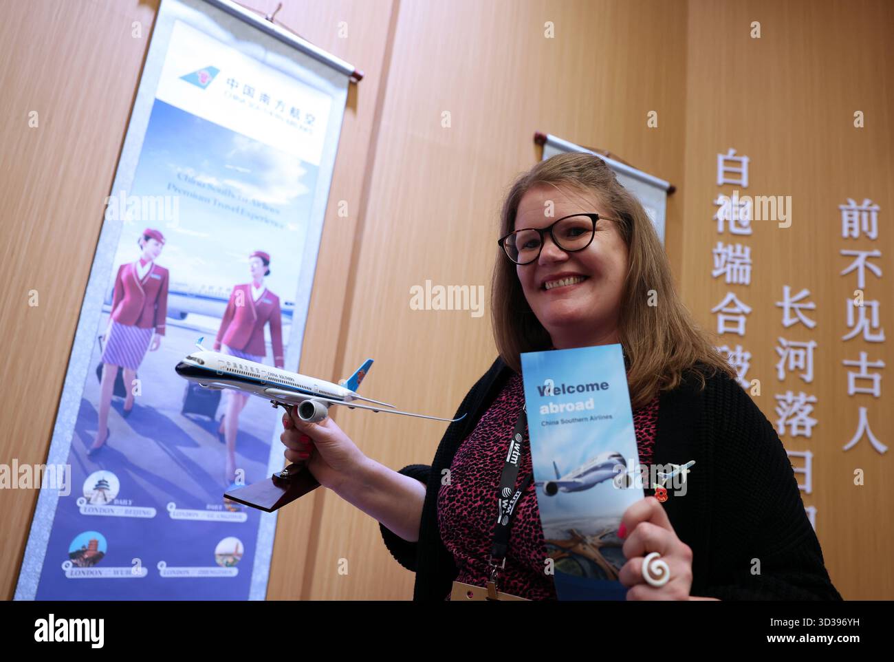 Londres, Grande-Bretagne. 4 novembre 2025. Un membre du personnel pose pour des photos avec une maquette d'avion au pavillon chinois du World Travel Market (WTM) Londres 2025 à Londres, Grande-Bretagne, le 4 novembre 2025. Le WTM London 2025 a ouvert ses portes mardi, le pavillon de la Chine attirant l’attention pour ses ressources touristiques abondantes et son attrait culturel. Crédit : Li Ying/Xinhua/Alamy Live News Banque D'Images
