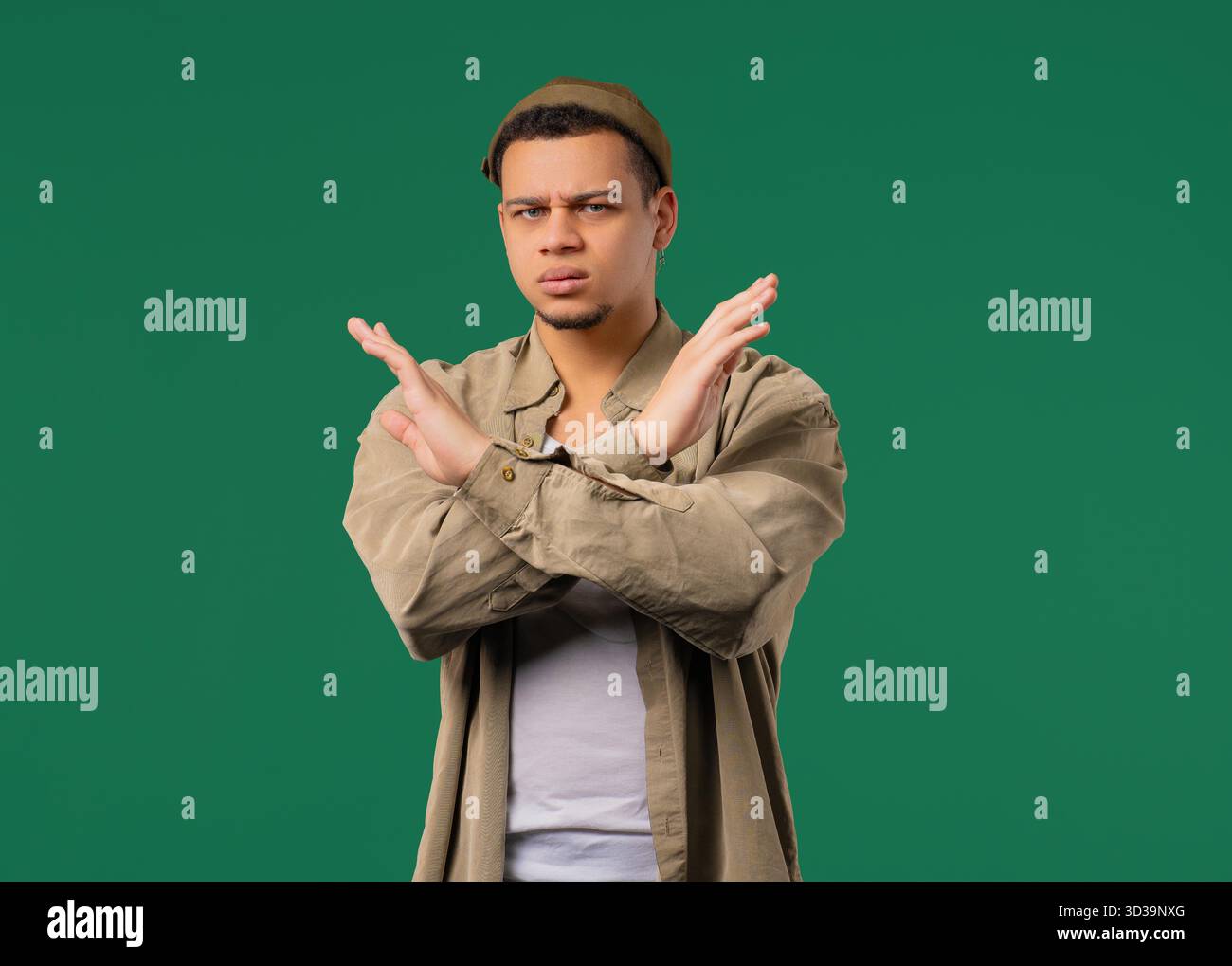 Grave homme insatisfait désapprouvant sans signe, refusant l'offre, hochant la tête désapprouvant. Nier, rejeter, être en désaccord, Portrait du jeune homme sur vert, réponse négative. Haute qualité || autorisation du modèle Banque D'Images