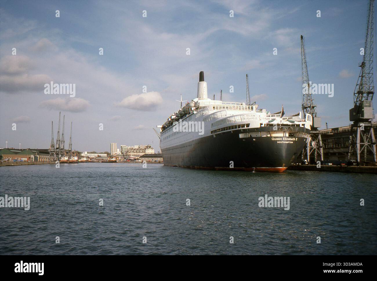 Hampshire, Angleterre. 1977 : photographie de la poupe du paquebot et navire de croisière, le S.S. Queen Elizabeth 2, amarré aux quais 43 et 44, Southampton Docks, à côté de Ocean terminal et prise le 28 octobre 1977. Construit sur la rivière Clyde, en Écosse, par John Brown & Company pour la Cunard Line, le navire, communément appelé QE2, était le navire amiral de la compagnie. Il effectue son voyage inaugural en 1969 et opère comme paquebot transatlantique et navire de croisière de 1969 à 2008. Visible est la distance est South Western House, le bâtiment du siège de Cunard. Banque D'Images