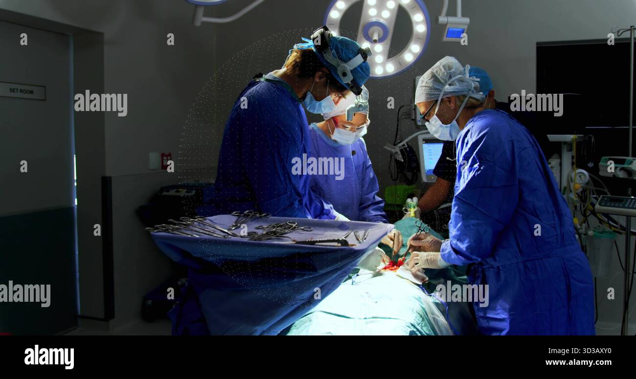 Équipe chirurgicale portant des gommages bleus pratiquant la chirurgie sous lumière chirurgicale, avec plateau d'instruments Banque D'Images
