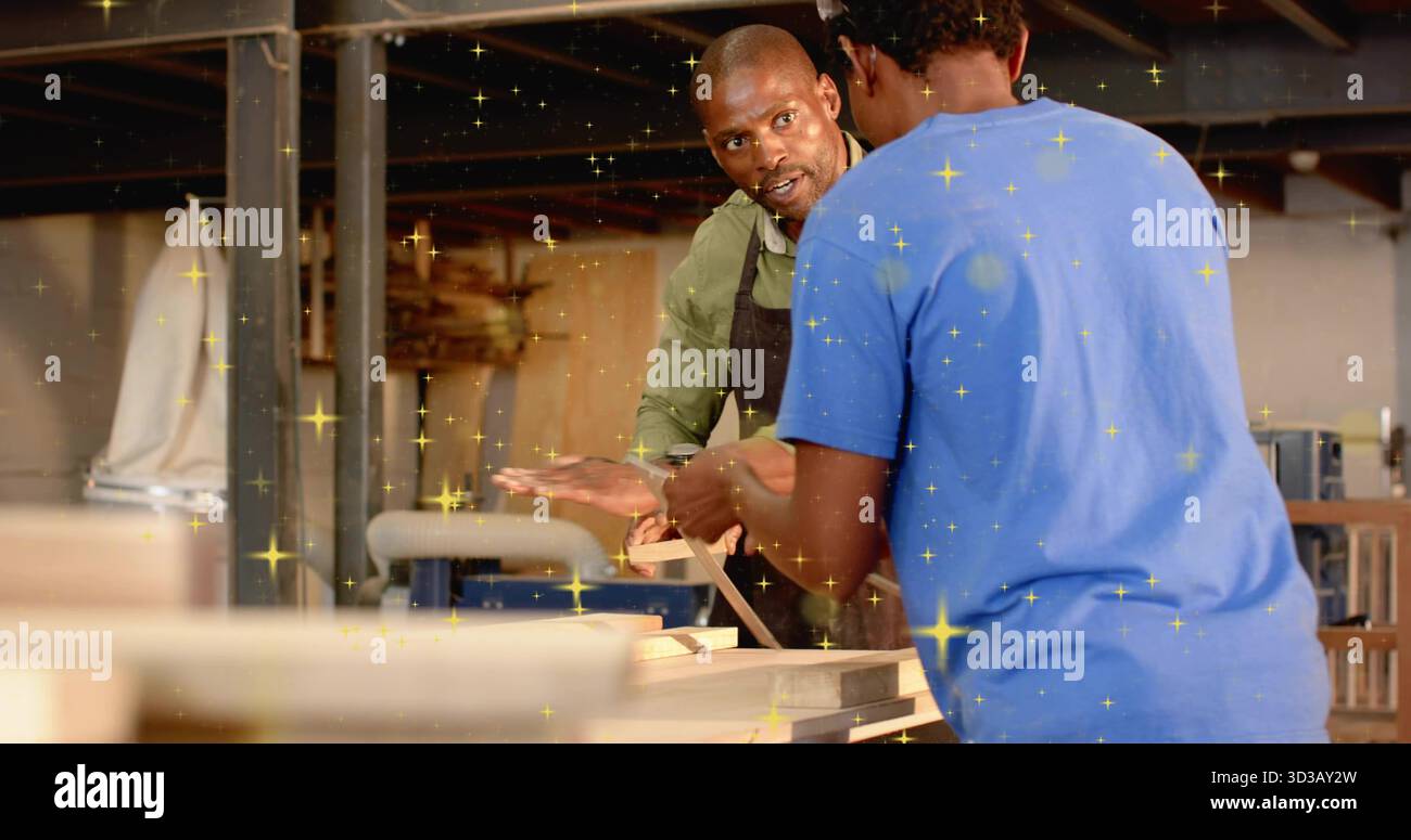 Mentorat charpentier guidant apprenti portant des lunettes de protection planche de rabotage dans l'atelier de bois, voilier modèle Banque D'Images
