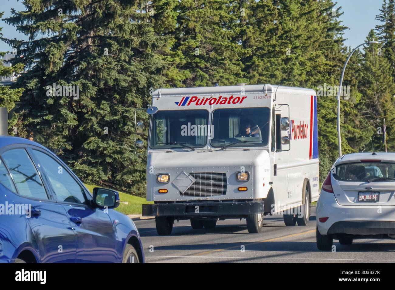 Calgary, Alberta, Canada. 8 juin 2025. Un camion de livraison Purolator, portant une marque bien en vue, navigue dans une rue bordée d'arbres à Calgary, symbolisant l'efficacité Banque D'Images