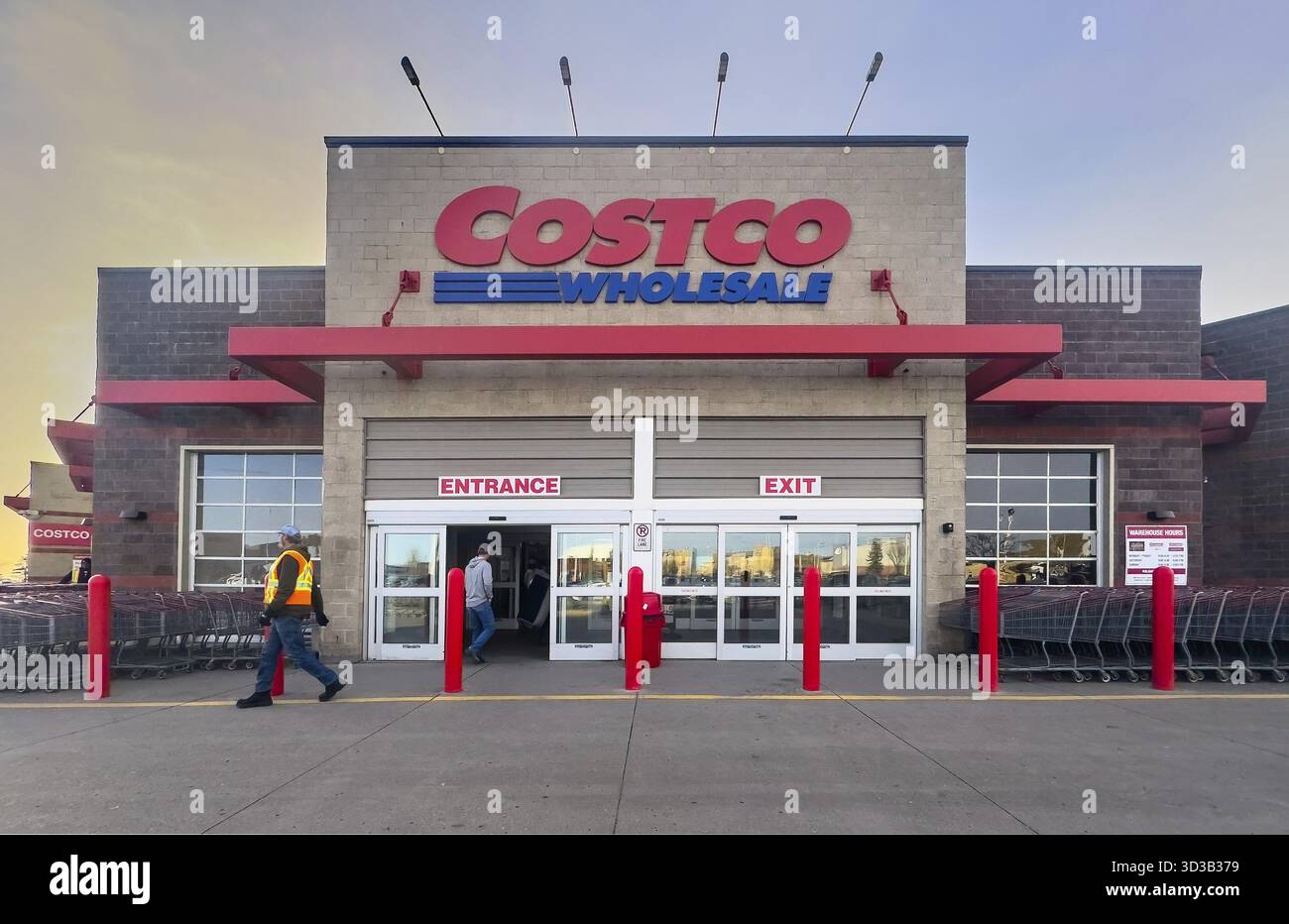 Calgary, Alberta, Canada. 10 avril 2025. Photo extérieure d'un magasin de gros Costco au crépuscule avec la signalisation Costco Wholesale et les personnes entrant et sortant. Banque D'Images