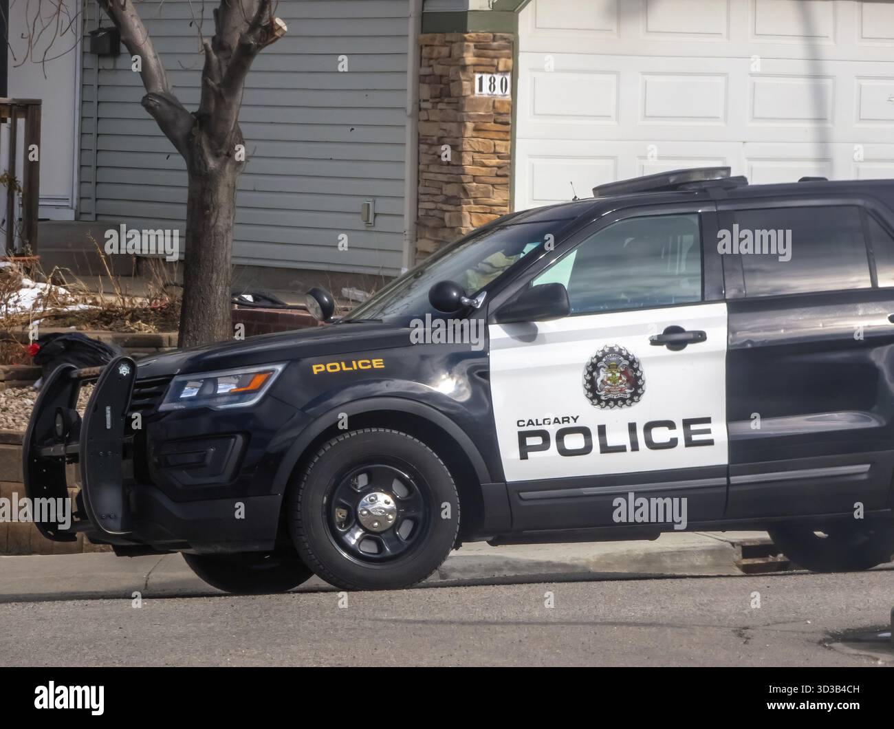 Calgary, Alberta, Canada. 12 mars 2025. Calgary police SUV garé sur une rue résidentielle, vue partielle sur la maison, journée ensoleillée Banque D'Images