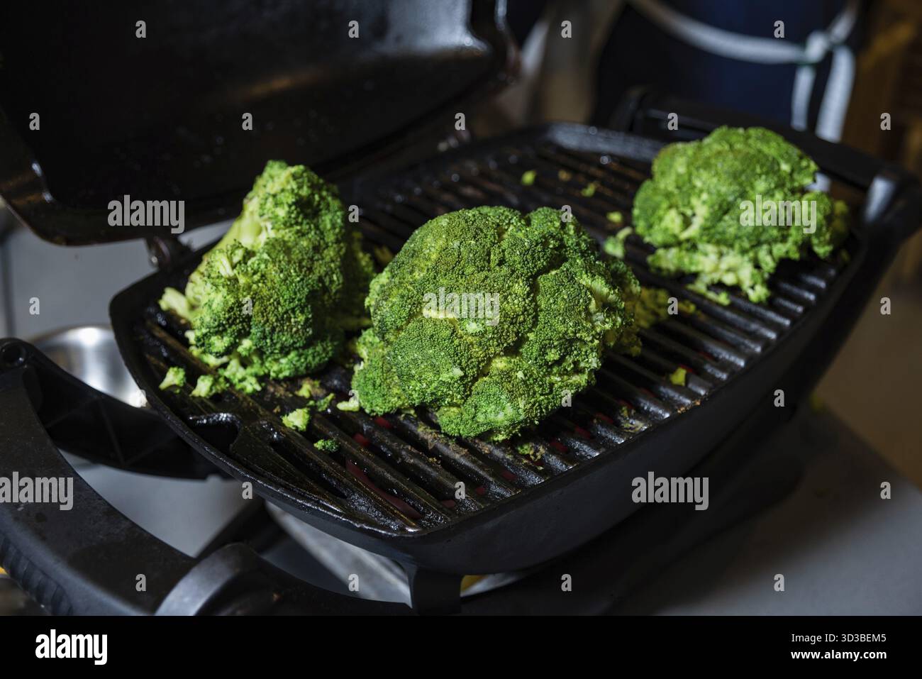 Aliments, têtes de brocoli grillées sur un gril électrique, présentant une méthode de cuisson saine pour les légumes à la texture et à la saveur carbonisées Banque D'Images