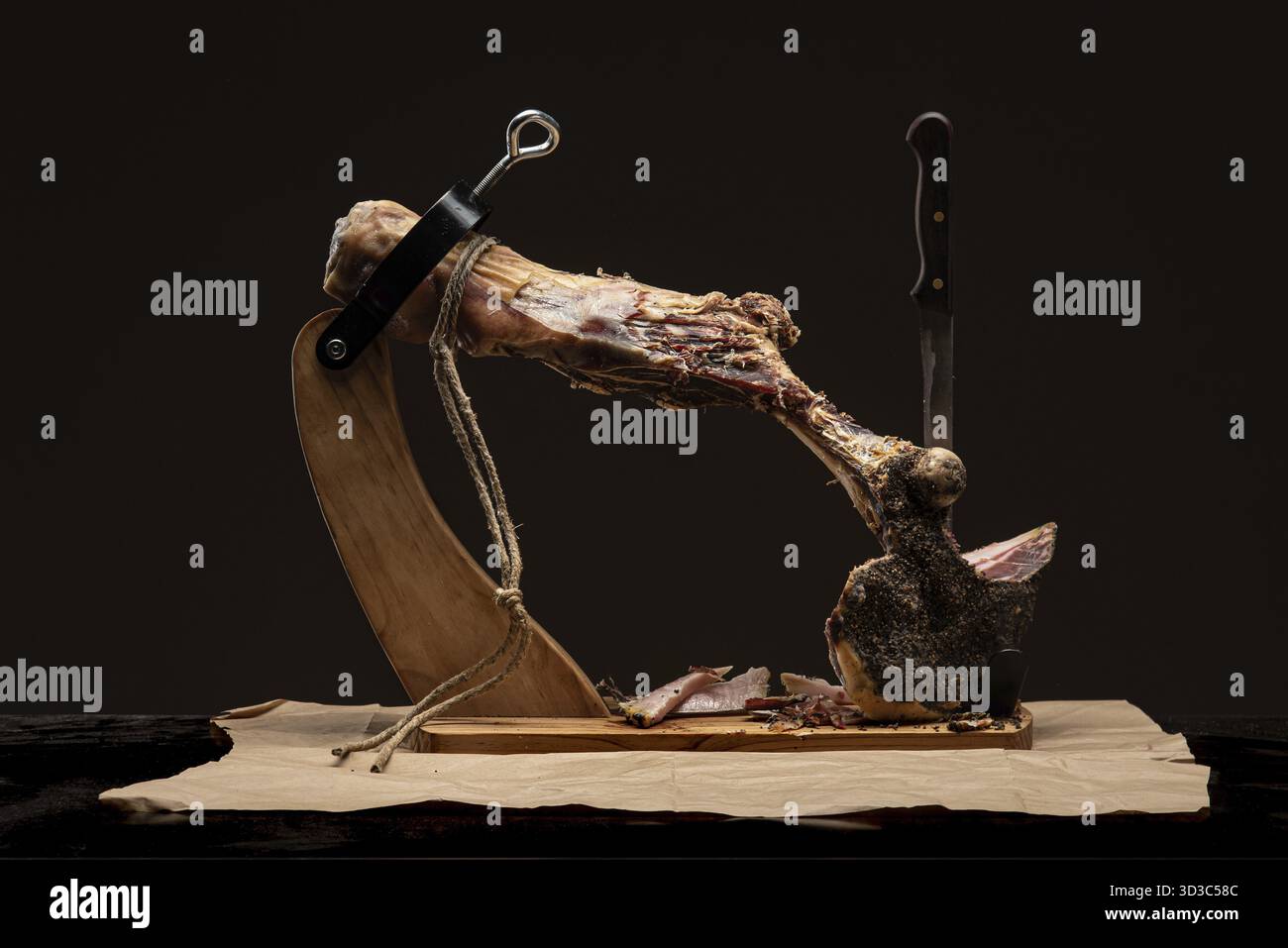 Jamon sur un support en bois pour couper la viande. Morceau de jamon sur jamonero. Jambon, jambon, prosciutto. Prise de vue en studio Banque D'Images
