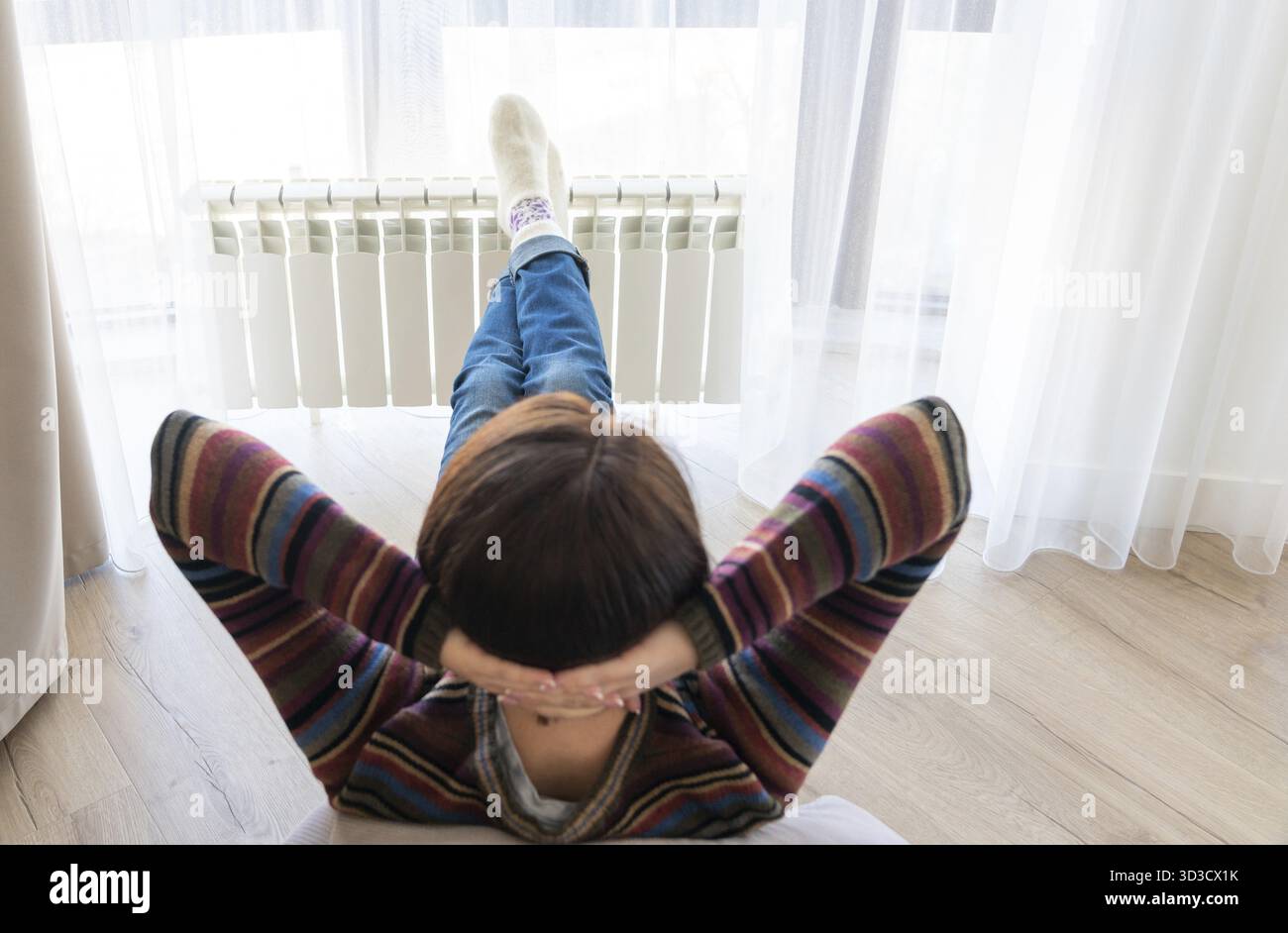 Femme portant sur marbre avec pieds dressé sur le radiateur pour réchauffer Banque D'Images