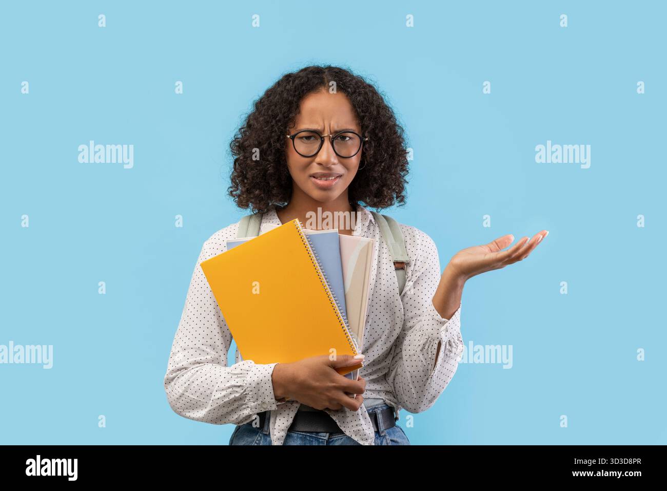 Étudiante noire frustrée luttant avec les devoirs sur fond bleu Banque D'Images