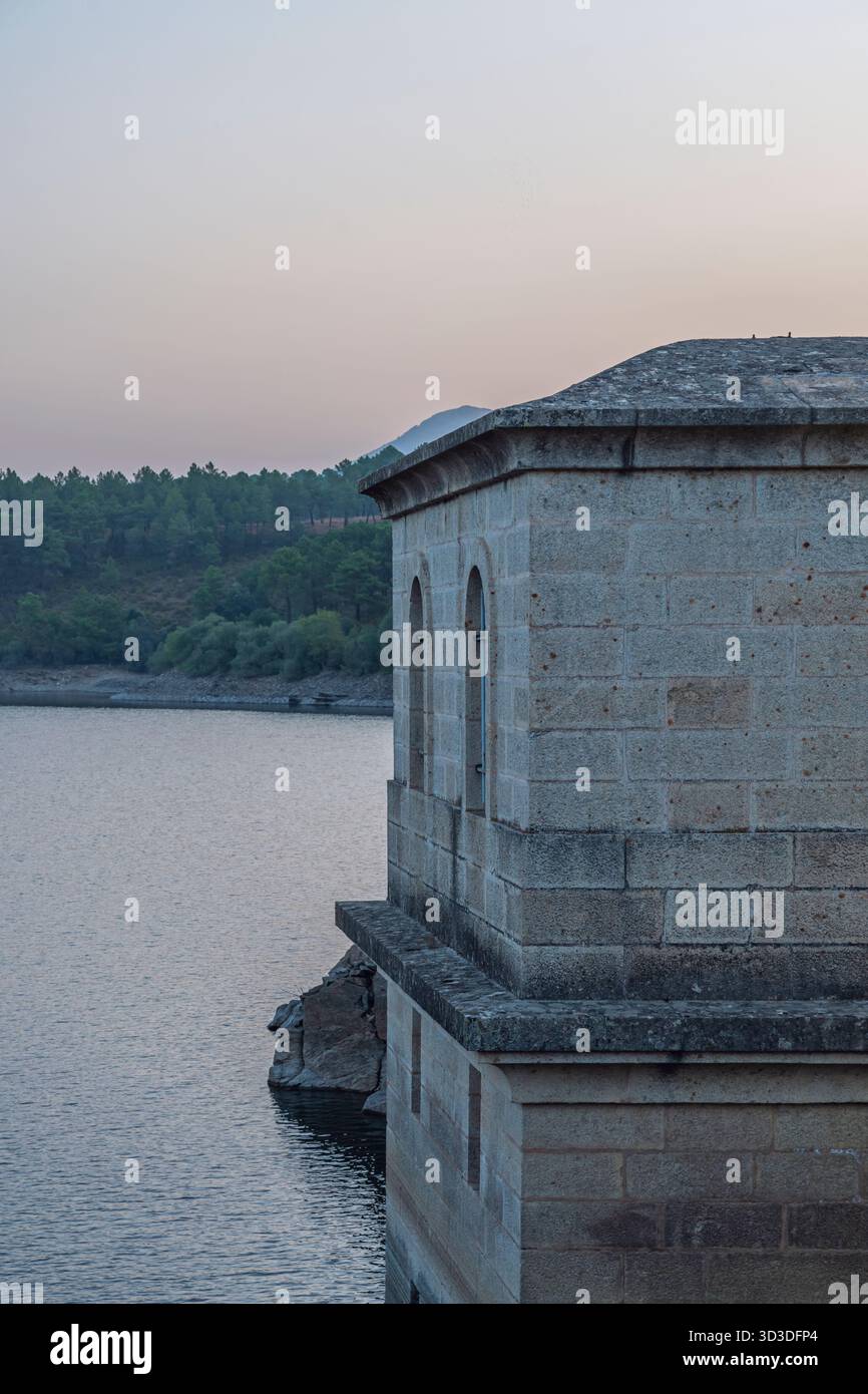 Réservoir par une journée venteuse avec de petites vagues se brisant contre le mur de soutènement, créant une mousse blanche éphémère Banque D'Images