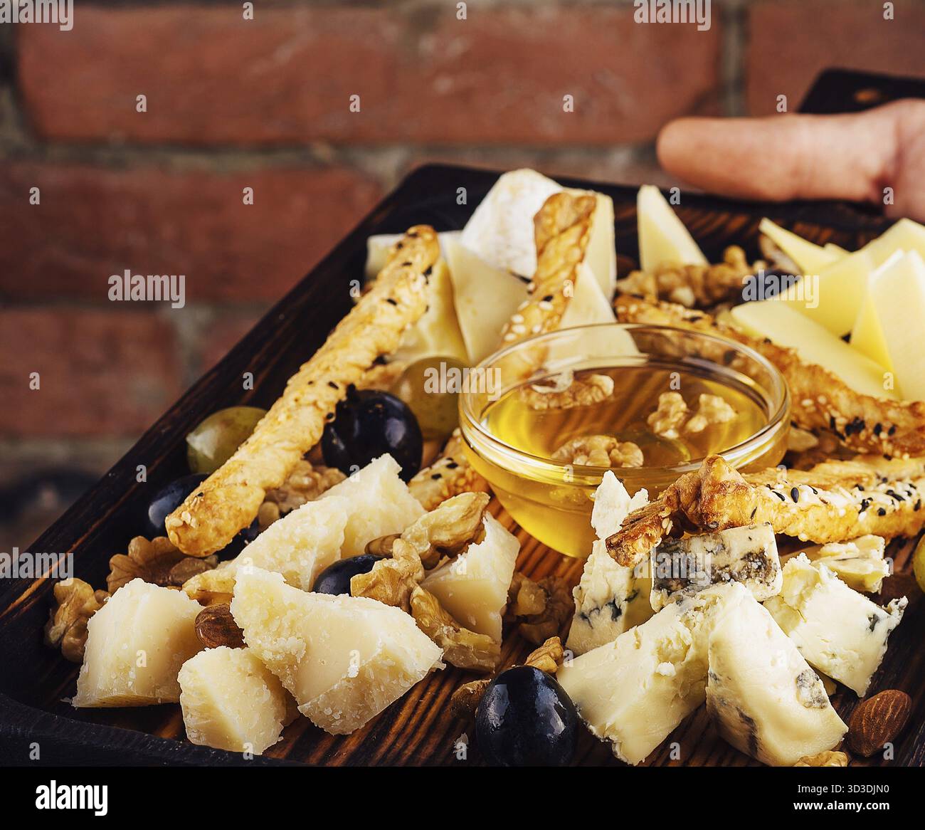 Nourriture, assiette de fromage avec miel, raisins et noix Banque D'Images