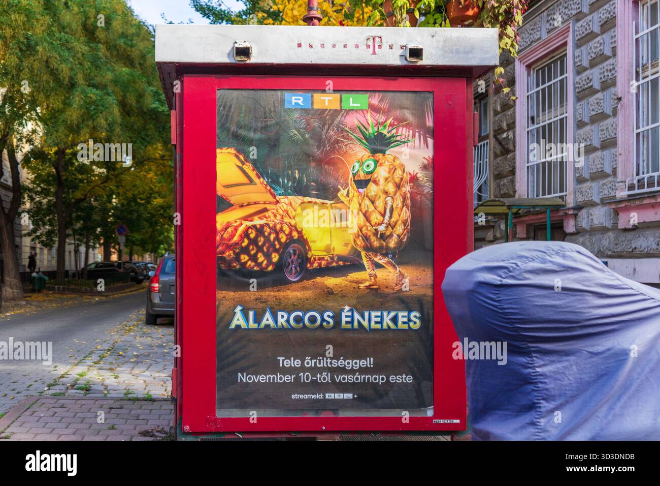 Affiche de rue à Budapest promouvant un spectacle de divertissement RTL avec un personnage coloré de costume d'ananas. Banque D'Images