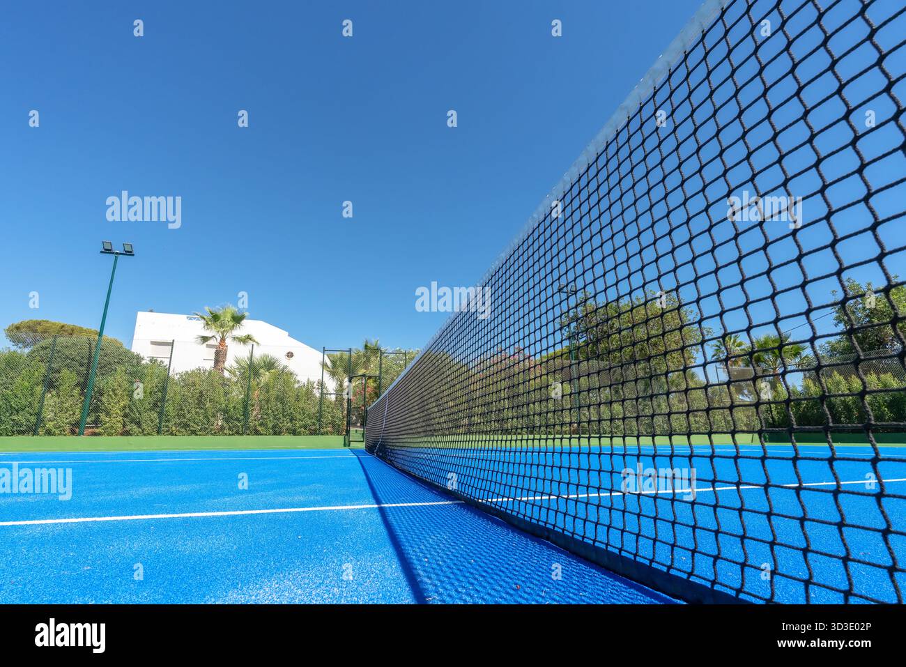 Stade de tennis ensoleillé, court ouvert sous le ciel lumineux, installations de tennis extérieures vives avec temps clair, court de tennis bien éclairé avec un environnement vivant Banque D'Images
