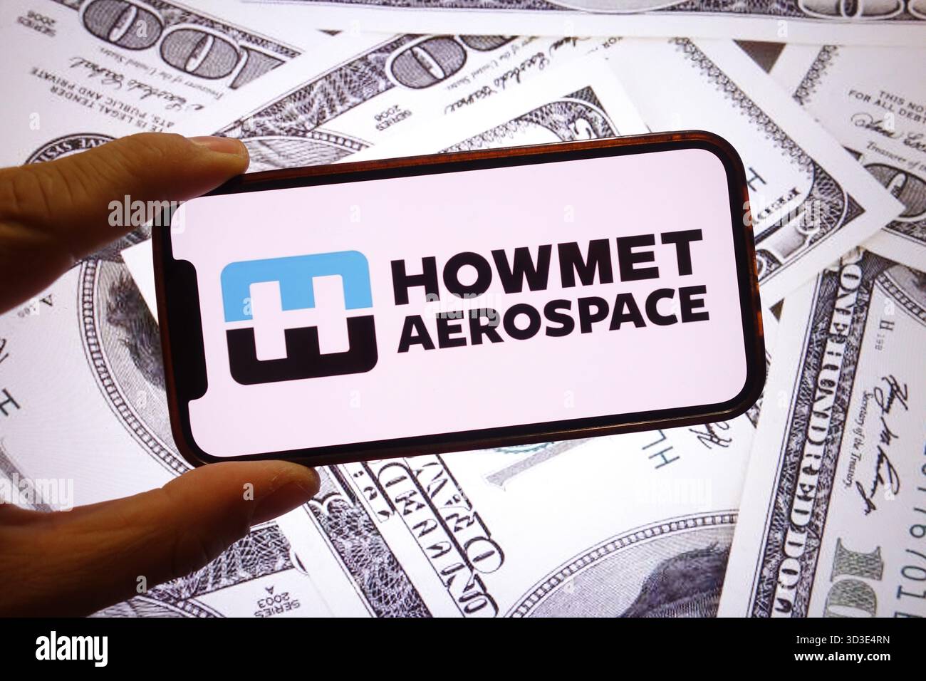 Dans cette illustration photo, le logo de la société Howmet Aerospace est affiché sur un écran de smartphone avec les billets de banque en dollars des États-Unis en arrière-plan. Banque D'Images
