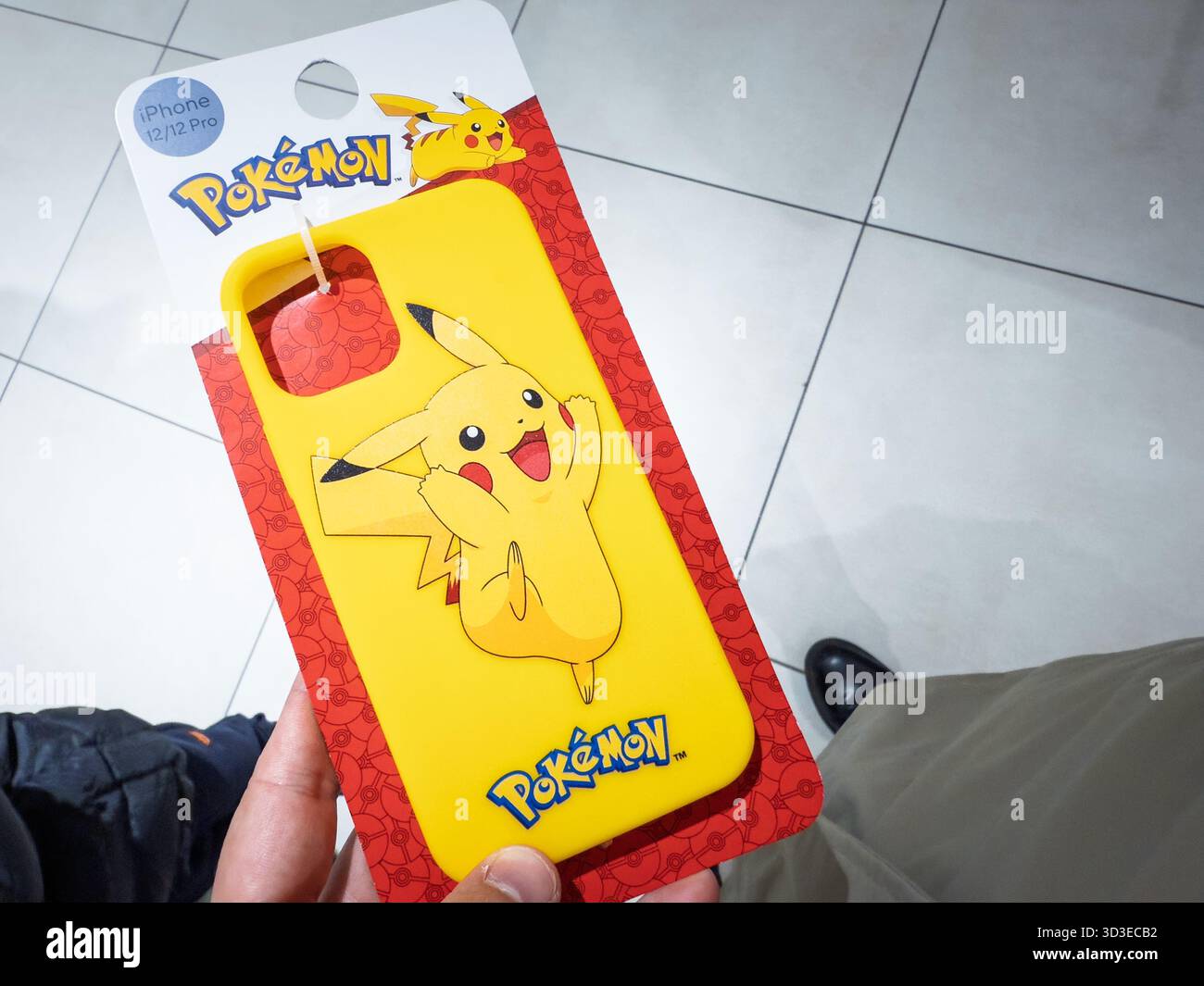 BELGRADE, SERBIE - 11 OCTOBRE 2025 : une main tient un étui de téléphone jaune vif avec le logo Pokemon et une joyeuse illustration Pikachu à l'intérieur d'un magasin Banque D'Images
