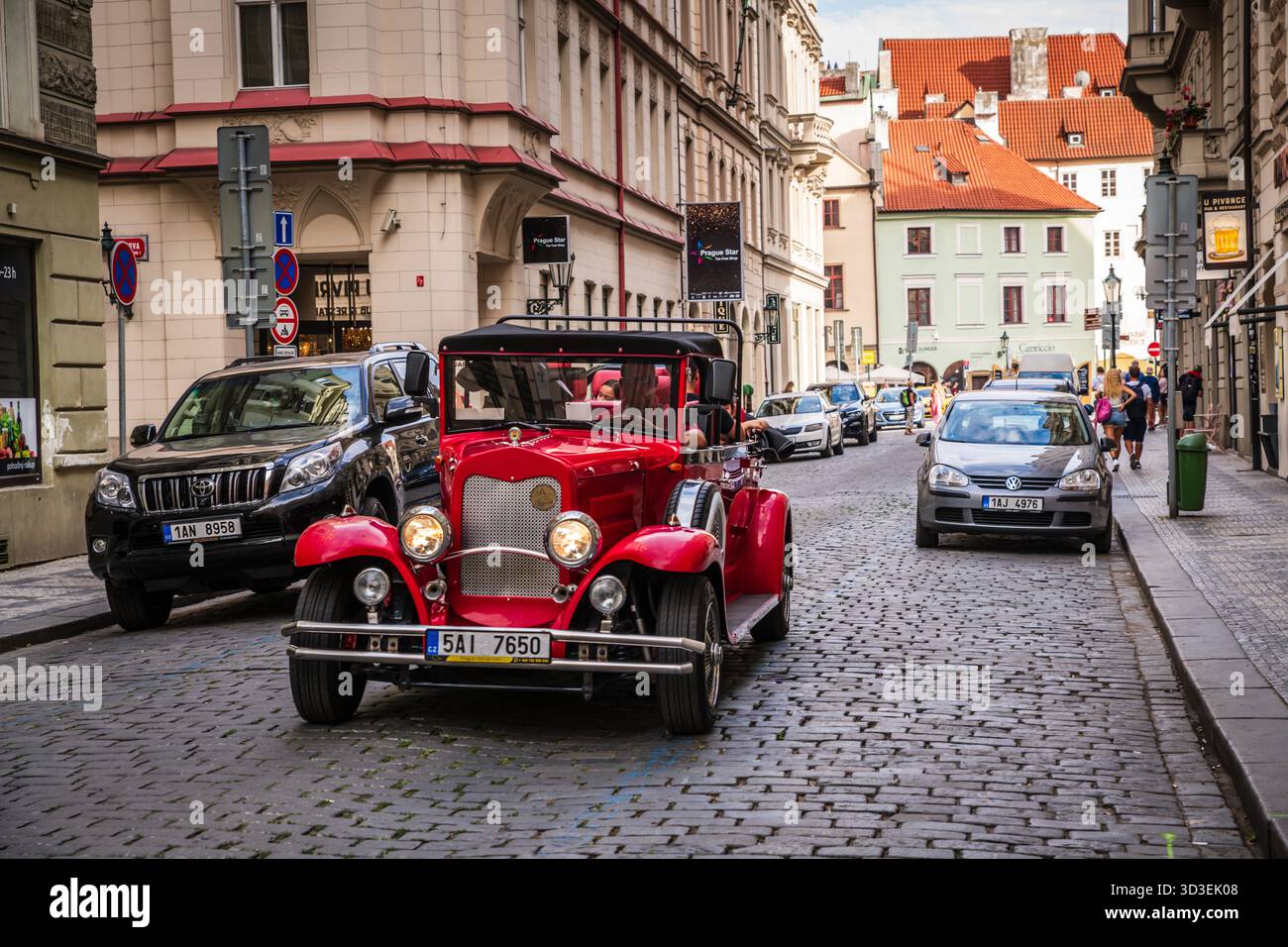 Visite de la vieille ville de Prague à bord d'une voiture rouge d'époque du XXe siècle. Banque D'Images