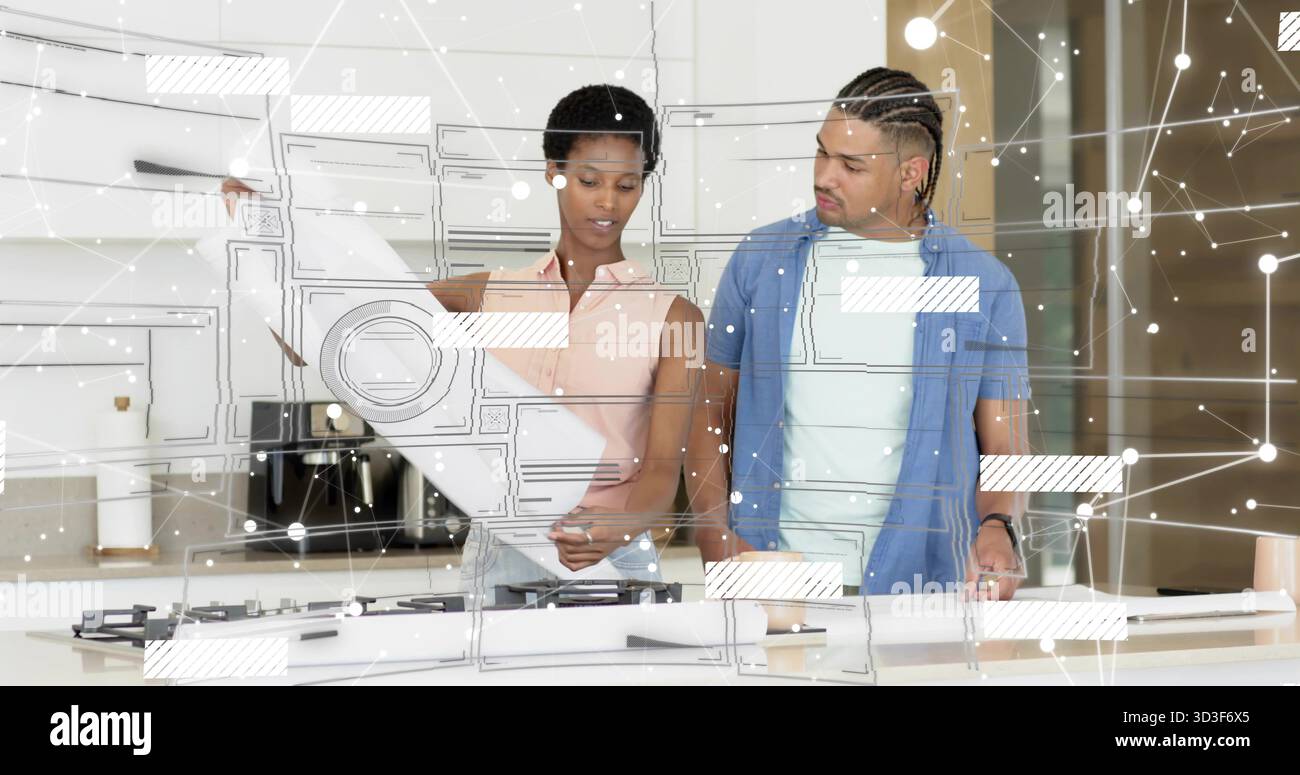 Couple étudiant le plan sur l'îlot de cuisine moderne, avec table de cuisson à gaz et graphiques de superposition Banque D'Images