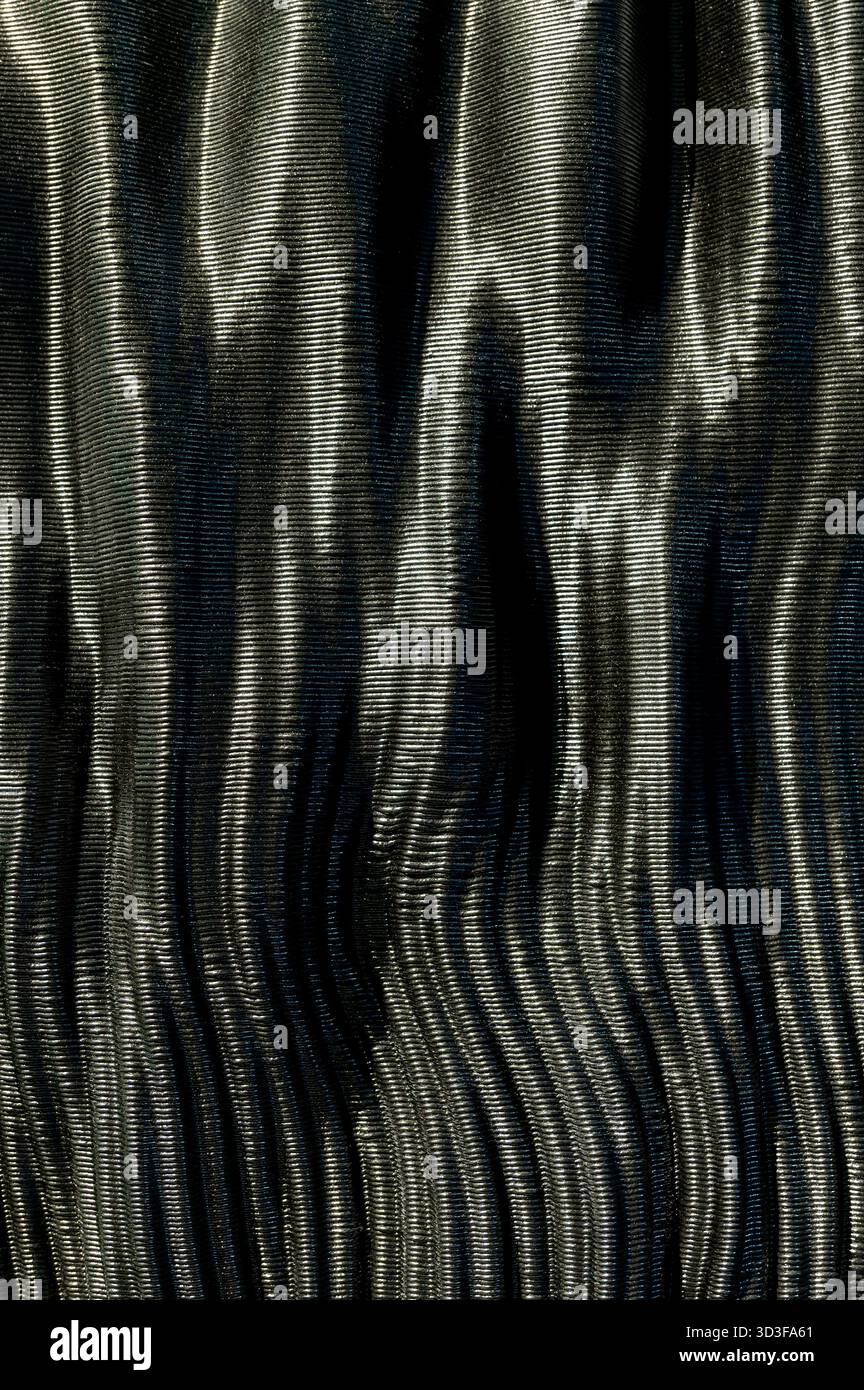 Texture en fibre de carbone noire montrant un motif nervuré avec des reflets et des ombres subtils Banque D'Images