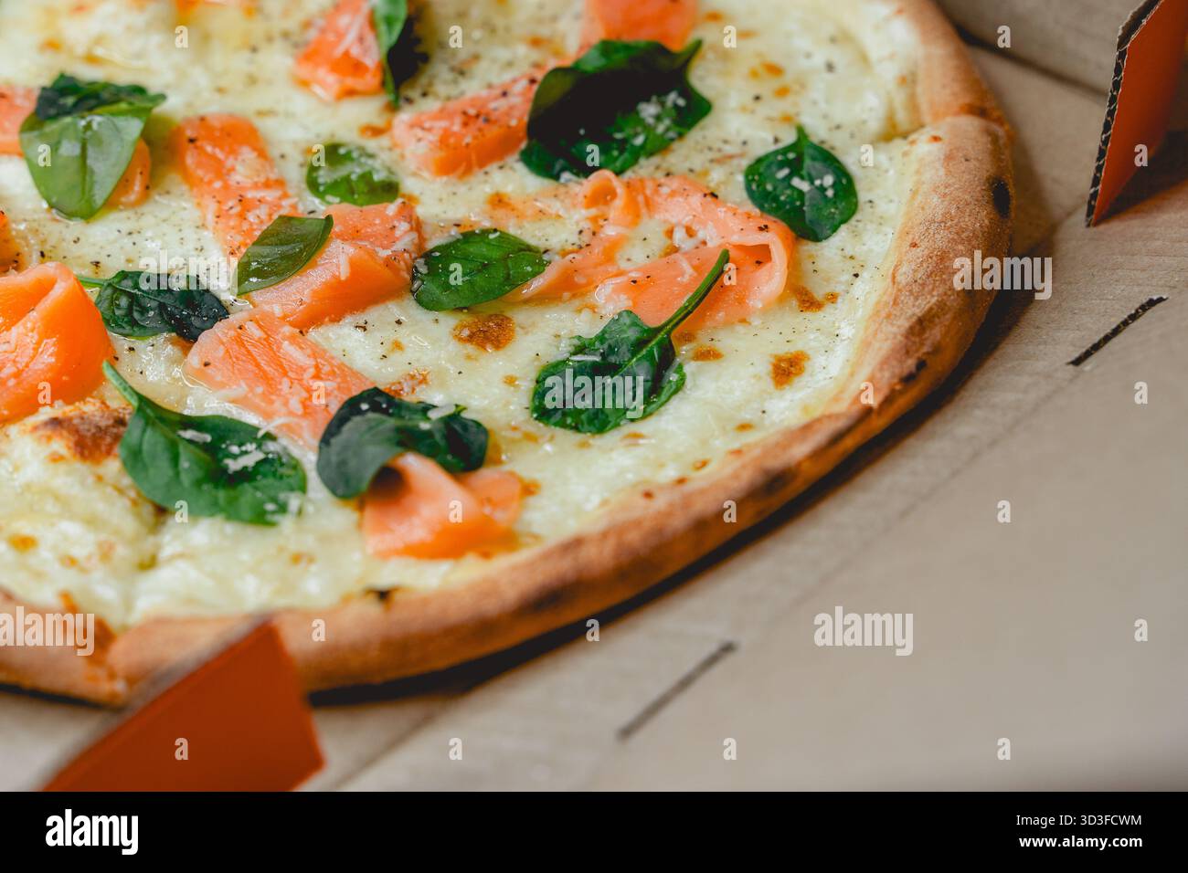 Pizza avec saumon et épinards dans une boîte Banque D'Images