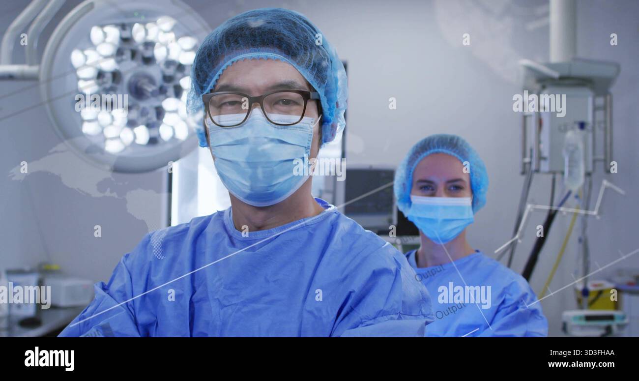 Chirurgiens debout portant des gommages bleus avec des capuchons dans la salle d'opération, avec lampe chirurgicale et statif IV Banque D'Images