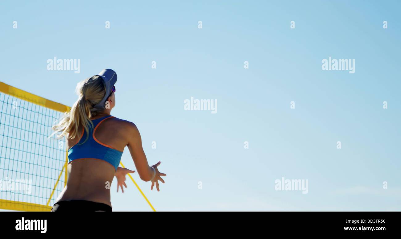 Préparation joueur de volley-ball de plage levant les bras près du filet jaune, portant un soutien-gorge de sport bleu, espace de copie Banque D'Images
