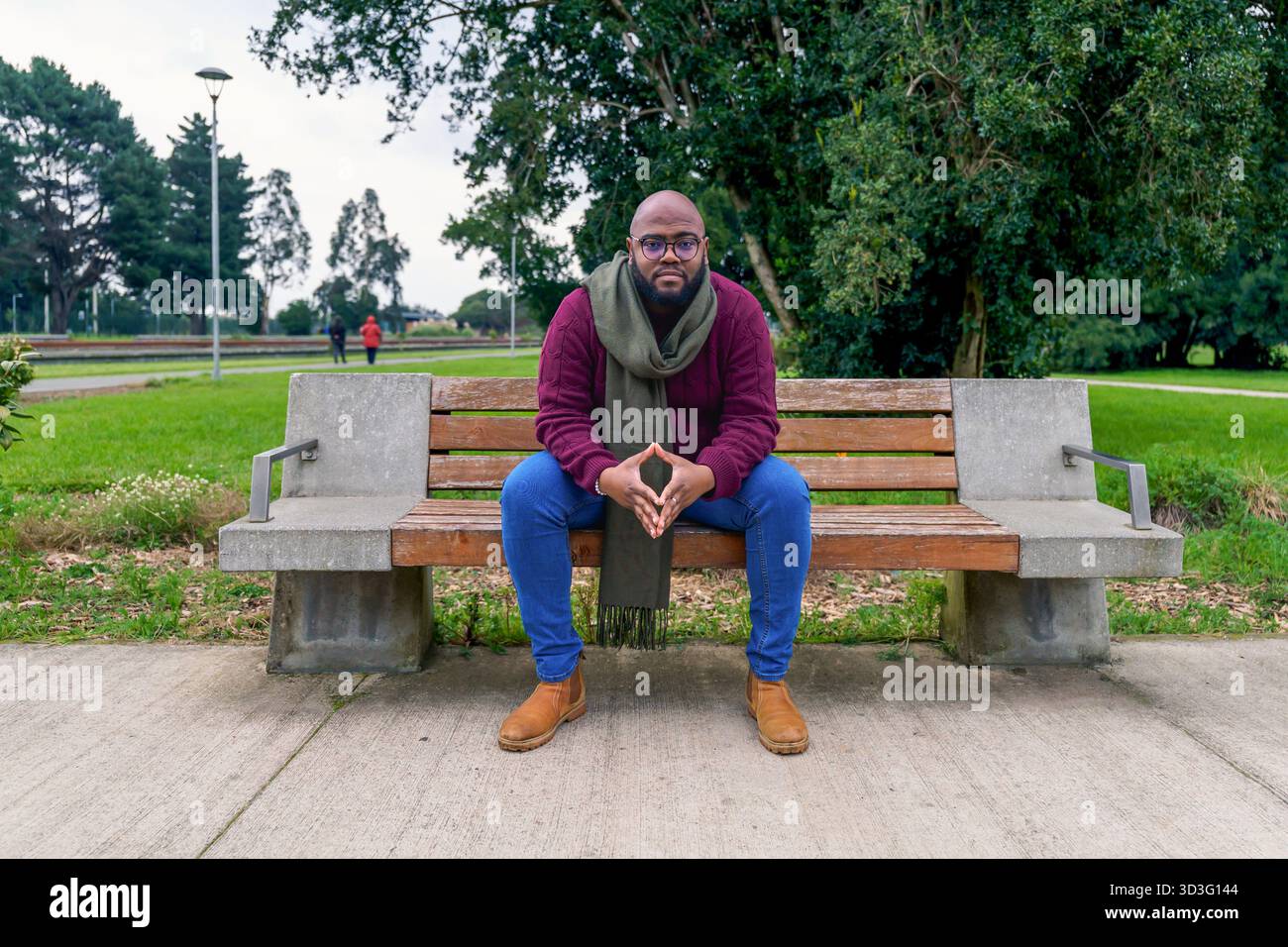 Un cubain est assis sur un banc de parc dans le sud du Chili, profitant d'une journée paisible. Il respire le calme, entouré par la nature et la verdure luxuriante, reflétant dans Banque D'Images