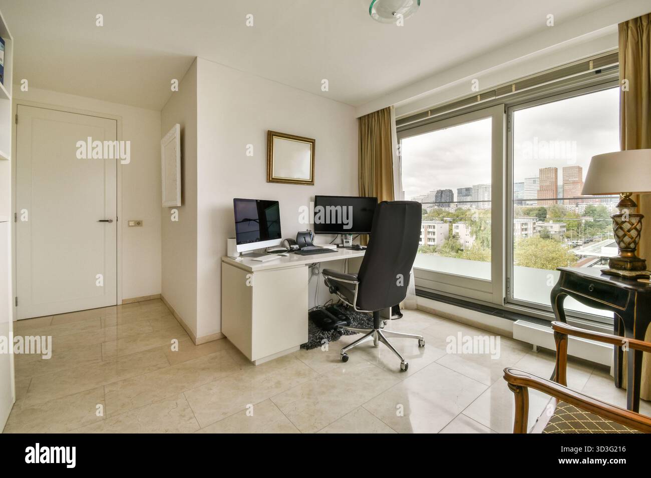 Un bureau à domicile élégant et moderne avec un bureau avec ordinateurs, chaise ergonomique et de grandes fenêtres mettant en valeur une vue sur la ville, créant une œuvre inspirante Banque D'Images