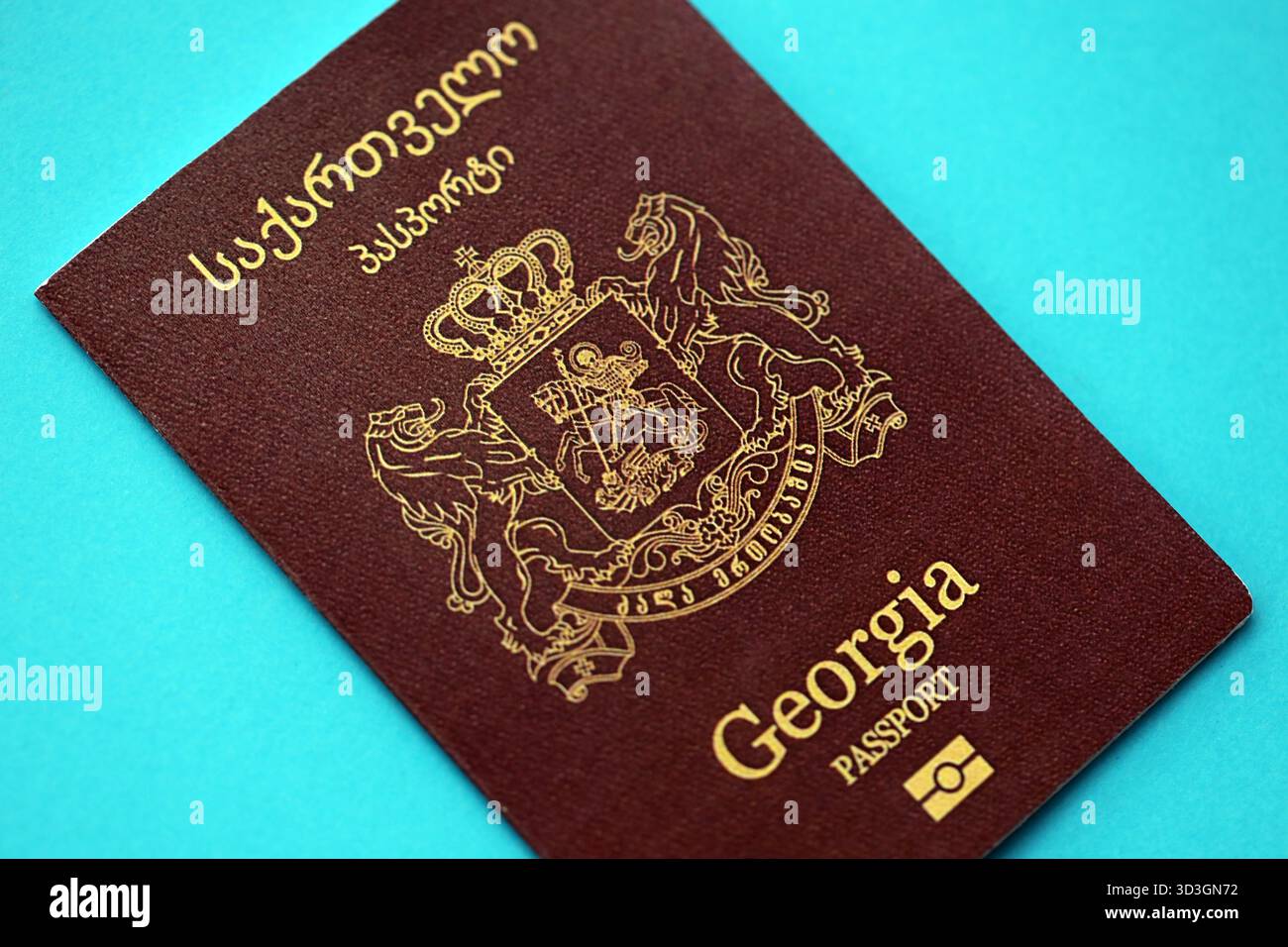Livre de passeport géorgien sur fond de papier bleu clair gros plan. Document de voyage sur surface bleue Banque D'Images
