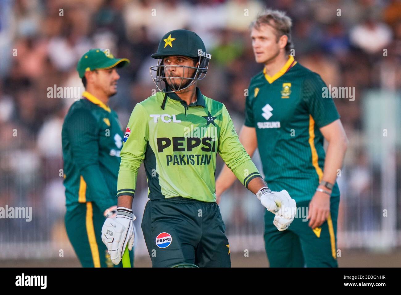 Pakistan's Saim Ayub, center, walks off the field as South Africa's Corbin Bosch, right, celebrates with teammates after his dismissal during the second one day international cricket match between Pakistan and South Africa, in Faisalabad, Pakistan, Thursday, Nov. 6, 2025. (AP Photo/Anjum Naveed) Banque D'Images