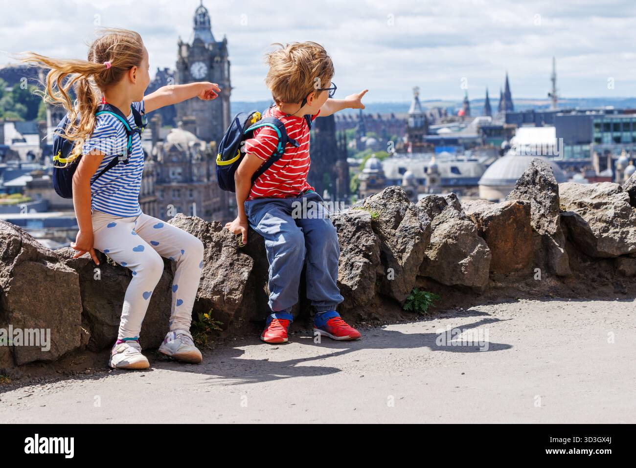 Les enfants excités avec des sacs à dos pointent la ville d'Edinburg, en Écosse Banque D'Images