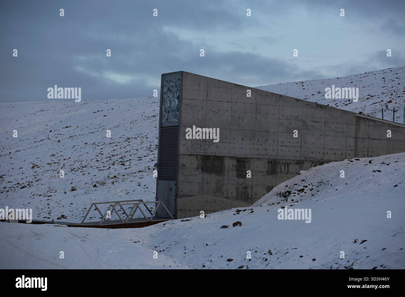 Longyerbeyen, Svalbard, grande structure en béton avec un toit métallique se trouve sur une colline enneigée. La structure est haute et étroite, avec une grande fenêtre sur le Banque D'Images