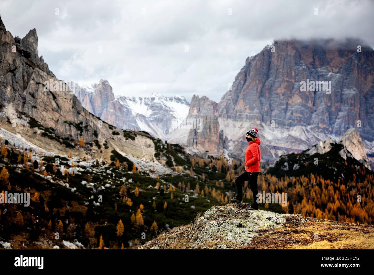Une randonneuse touristique debout et profitant de la vue panoramique spectaculaire automnale de l'emblématique Col du Giau dans les magnifiques Dolomites, en Italie. Banque D'Images