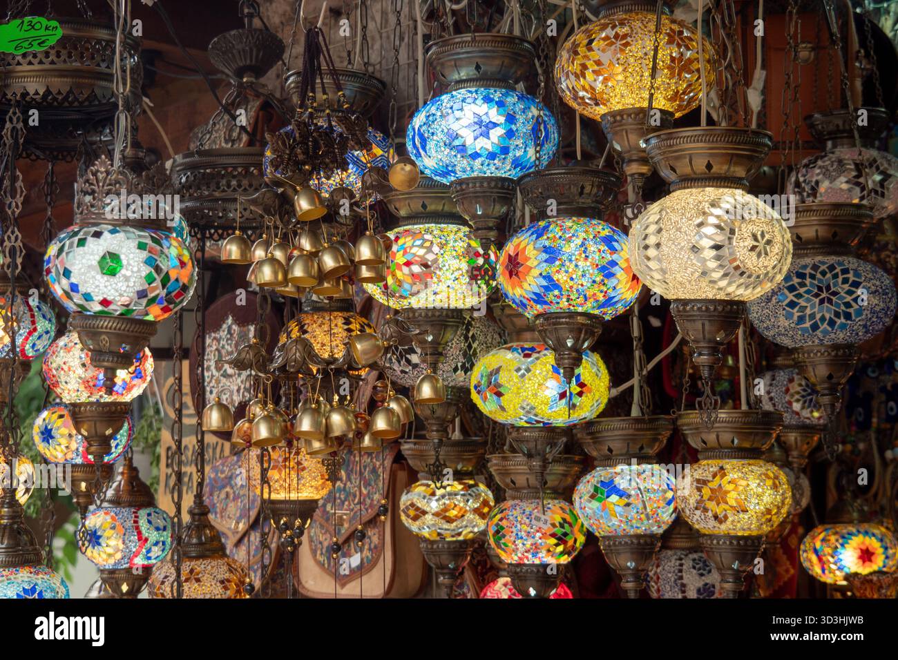 Lampes suspendues colorées en mosaïque et lanternes dans un marché traditionnel, lumières décoratives en verre créant des motifs et des textures vibrants. Banque D'Images