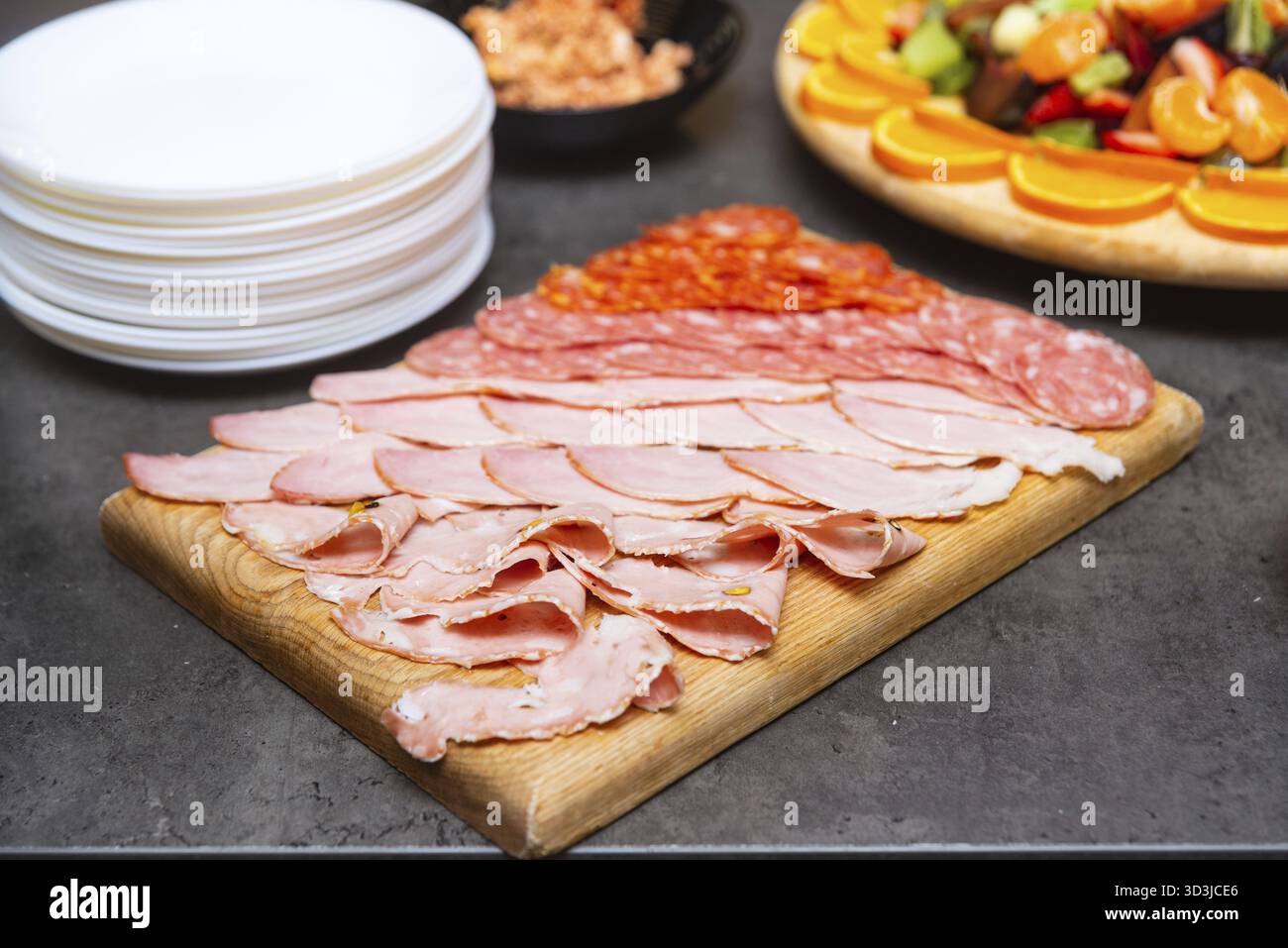 Nourriture, planche de bois avec un assortiment de viandes salées tranchées, y compris le salami, le jambon et la mortadelle, idéal pour les hors-d'œuvre ou les buffets Banque D'Images