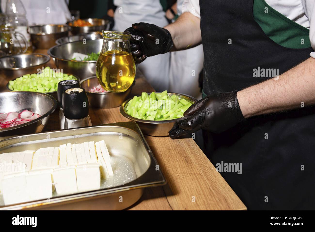 Nourriture, divers légumes fraîchement hachés et fromage feta préparés dans des bols, avec une cruche d'huile d'olive prête à vinaigrer une salade Banque D'Images