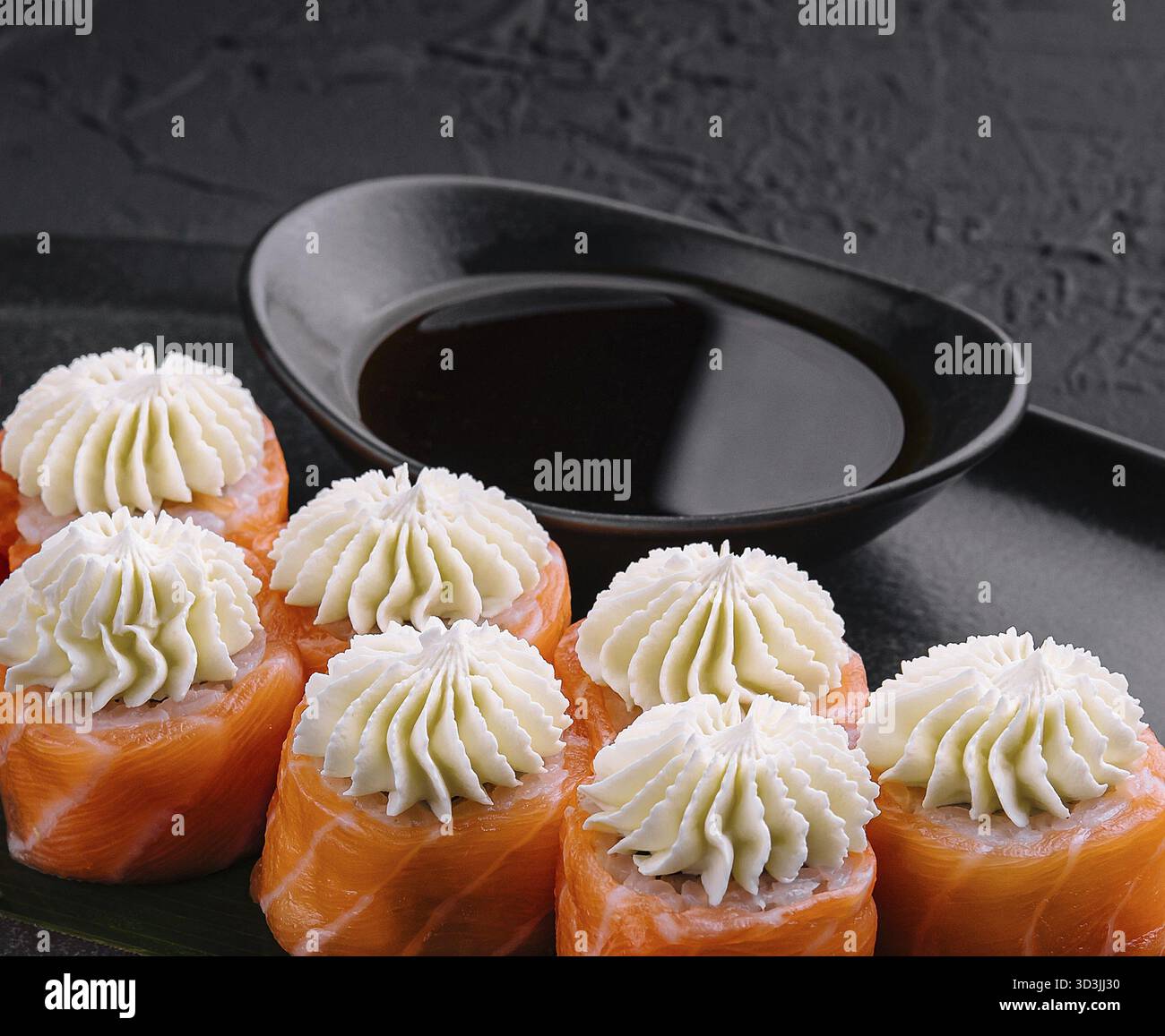 Nourriture, Sushi de Philadelphie avec fromage de Philadelphie sur assiette asiatique noire Banque D'Images