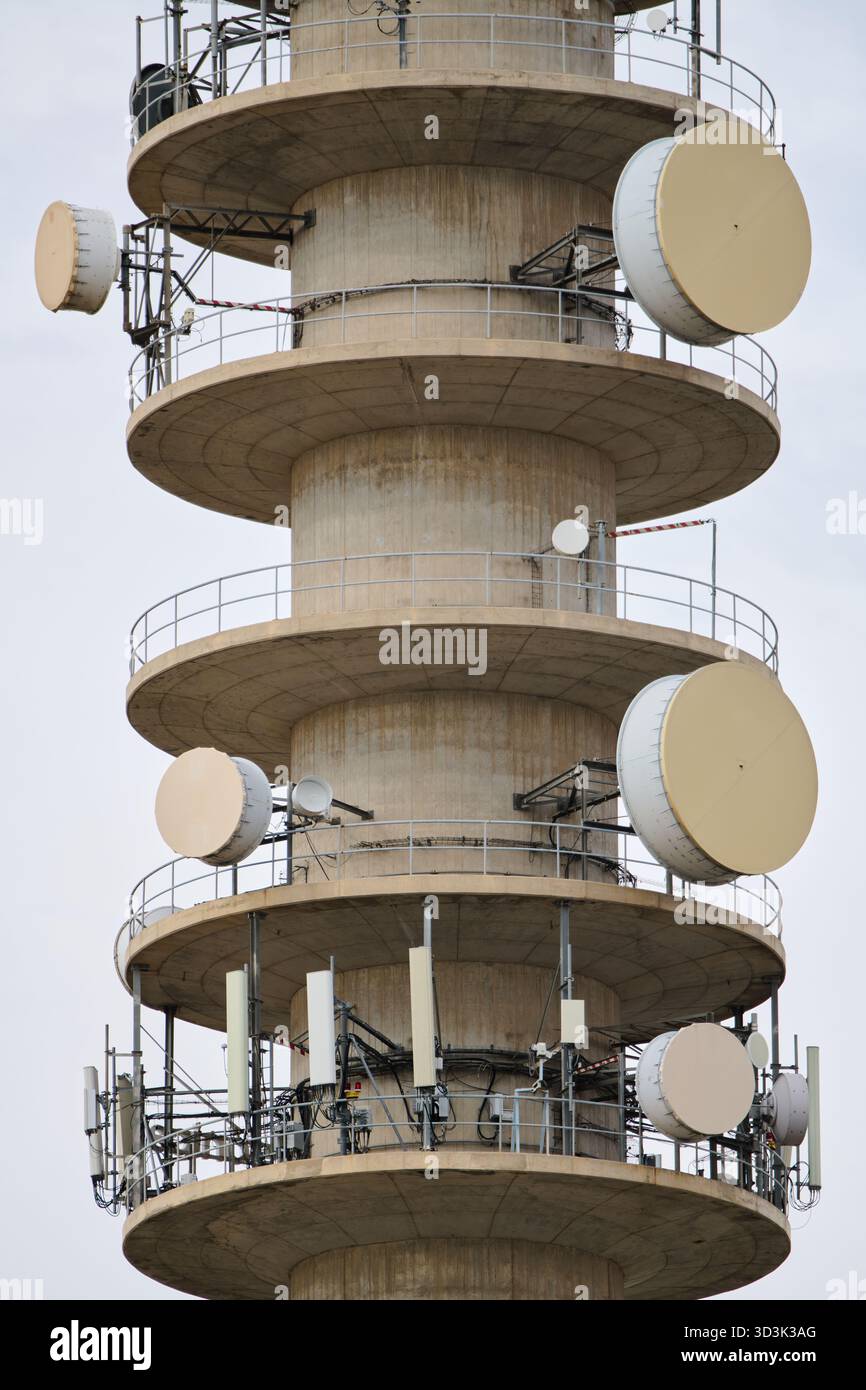 Gros plan d'une tour de télécommunications en béton avec un ciel blanc. Banque D'Images