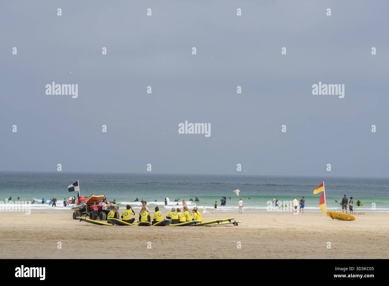 Ives, Angleterre - mai 2018 : Groupe d'adeptes du surf assis sur leurs planches de surf écoutant le moniteur de surf sur la plage, Cornwall, Royaume-Uni Banque D'Images