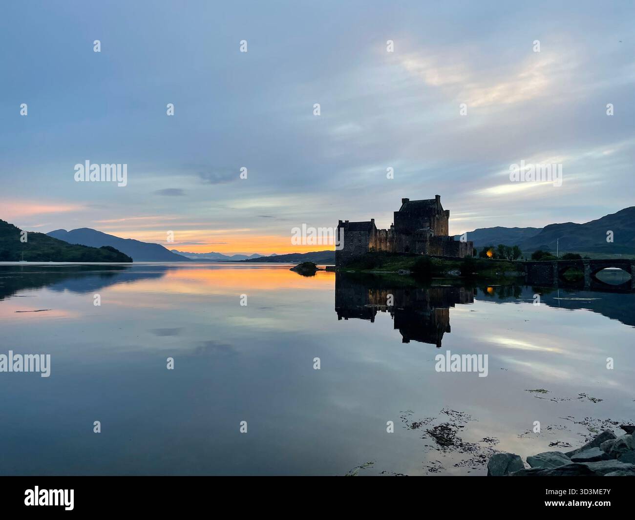 Lumière douce du soir sur le château d'Eilean Donan près de Dornie, reflétée dans les eaux calmes du Loch Duich dans les Highlands écossais, en Écosse. - Image de stock capturée avec un smartphone