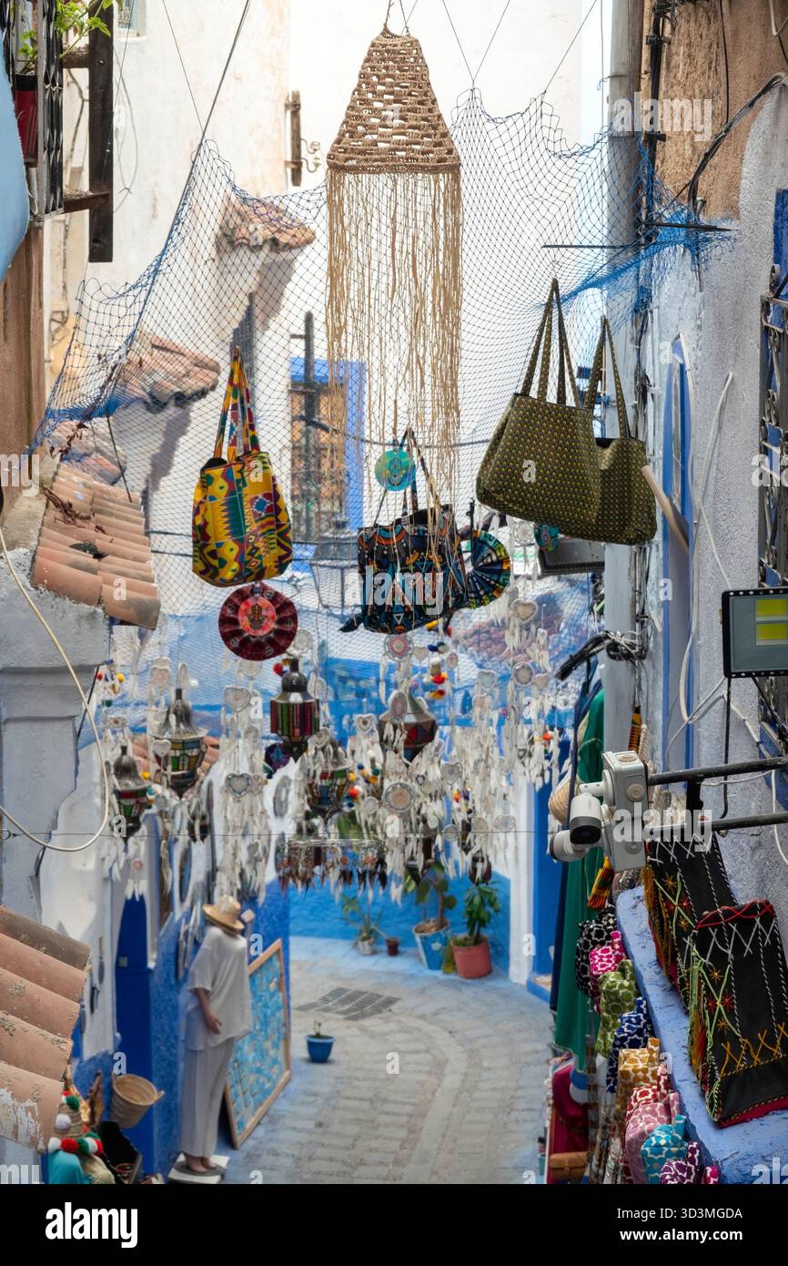 Ruelle bleue et blanche à Chefchaouen, au Maroc, est fortement décorée. De nombreux attrapeurs de rêves blancs et des lanternes marocaines colorées pendent au-dessus de vous, de la créatine Banque D'Images