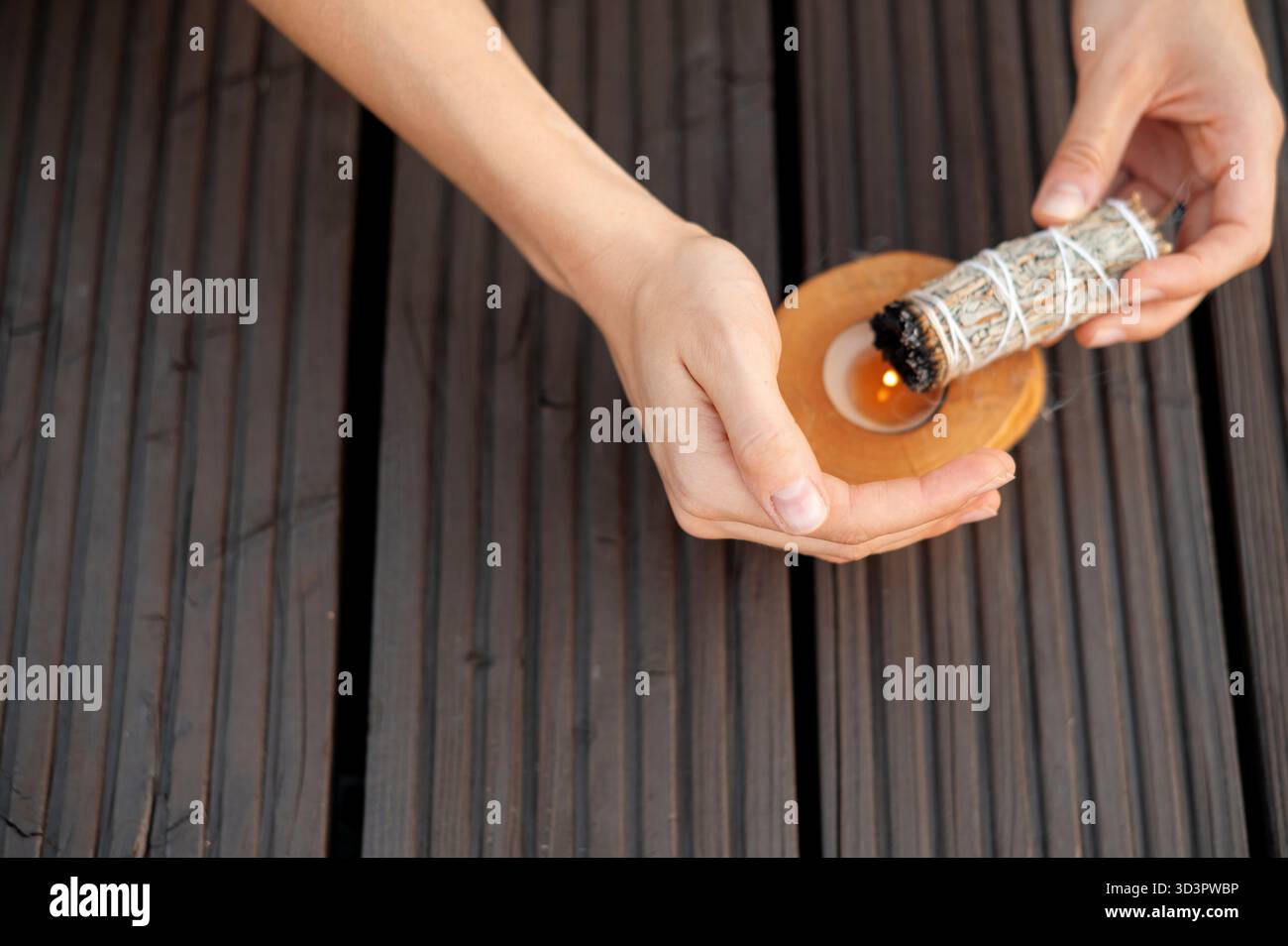 Mains tenant Smudge Stick sur plat en bois Banque D'Images