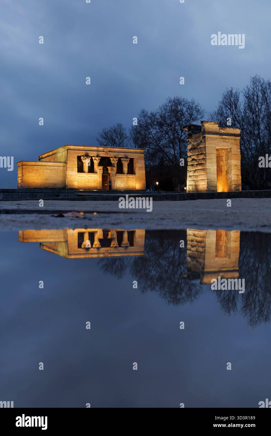 Le temple de Debod, une ancienne structure égyptienne, est illuminé au crépuscule à Madrid, se reflétant dans un étang voisin. Ce monument historique enrichit Banque D'Images