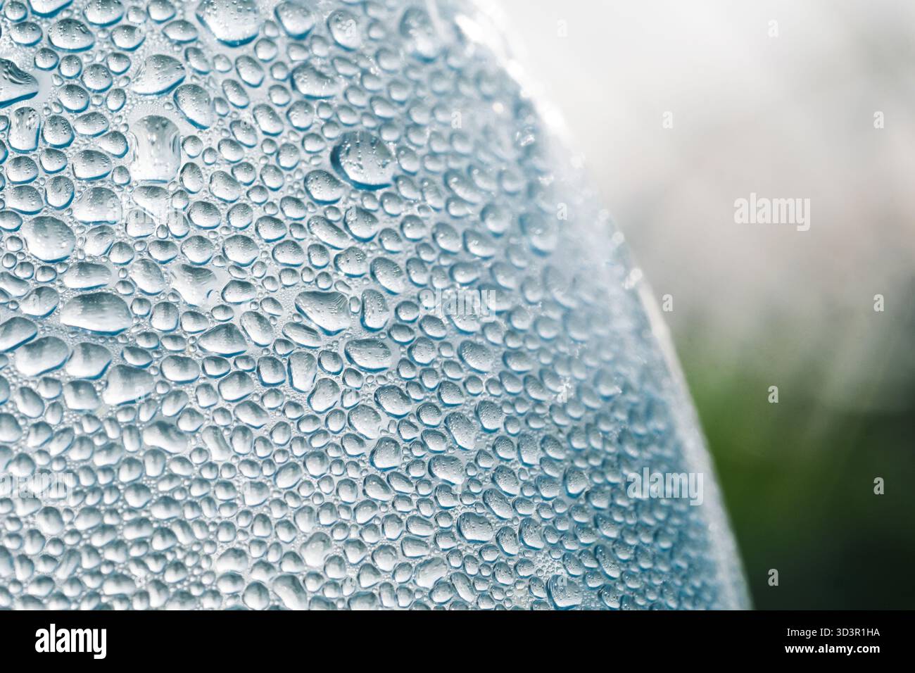 Gros plan macro capturant de nombreuses gouttes d'eau sur une surface, créant une texture fascinante avec des tailles et des reflets variables, mettant en valeur le b Banque D'Images
