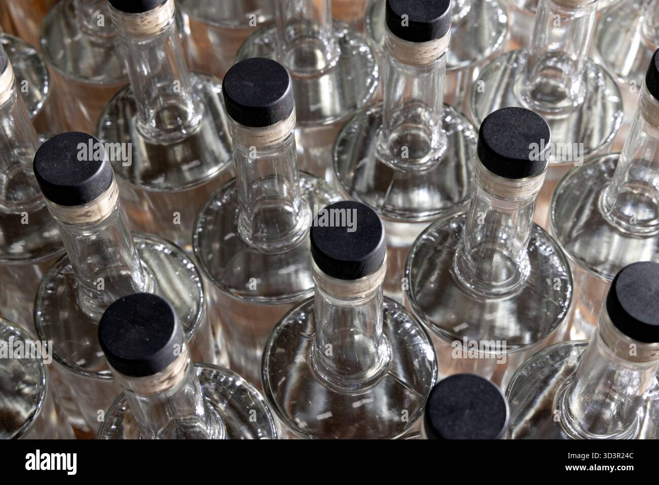 Groupe de bouteilles en verre transparent avec bouchons noirs Banque D'Images