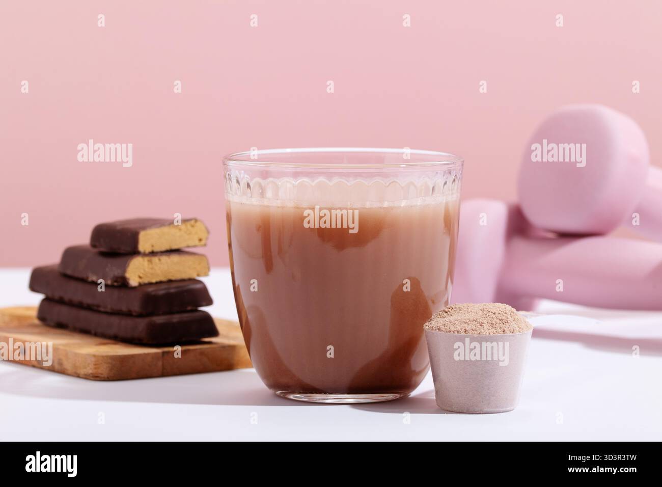 Gros plan d'une boisson protéinée, barres protéinées et poudre protéinée sur un fond rose doux avec équipement d'entraînement. Met l'accent sur la forme physique et la nutrition e Banque D'Images